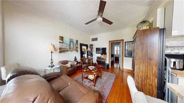 living area with visible vents, ceiling fan, and wood finished floors