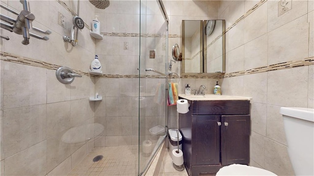 full bath featuring vanity, toilet, tile walls, and a shower stall