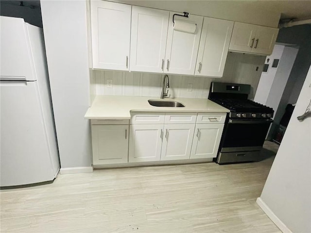 9 Corso Ct, Brooklyn, NY 11223 - kitchen with freestanding refrigerator, stainless steel gas range oven, a sink, and baseboards