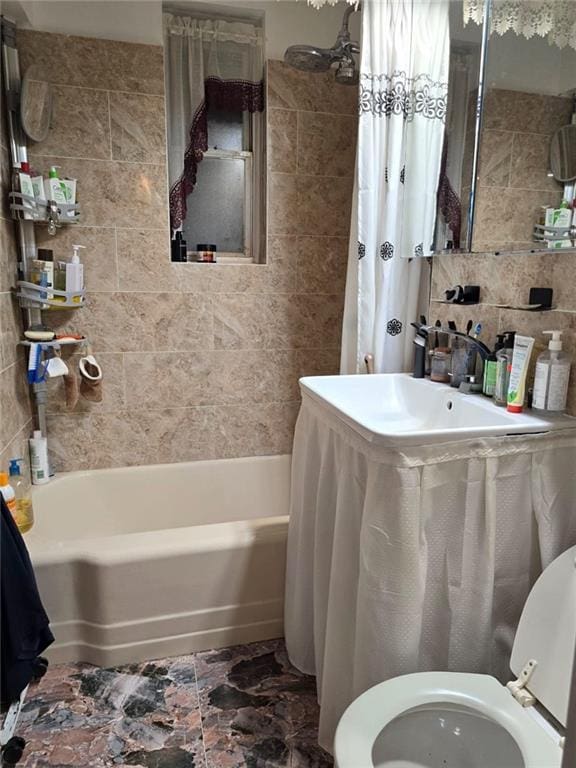 full bathroom with tile walls, toilet, and shower / bath combo with shower curtain