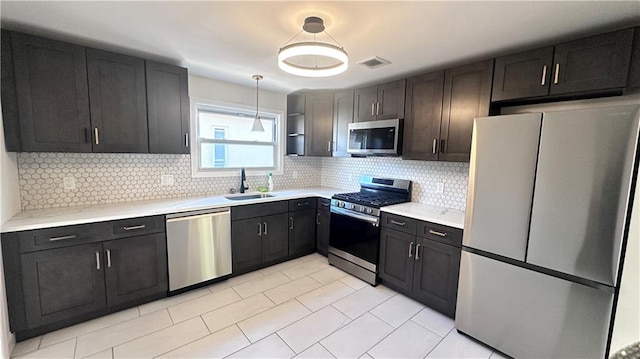 kitchen with visible vents, a sink, decorative backsplash, light countertops, and stainless steel appliances