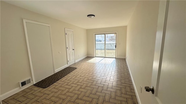 unfurnished room featuring baseboards and visible vents