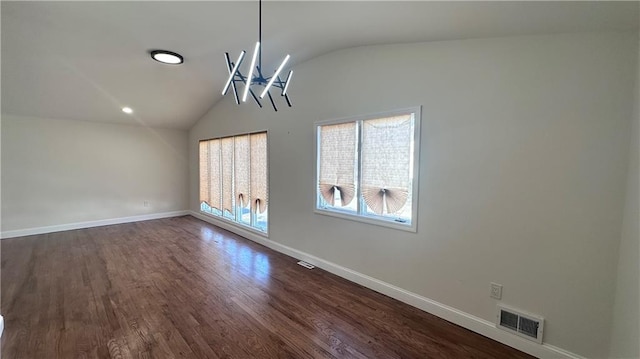 unfurnished dining area featuring dark wood finished floors, visible vents, baseboards, and vaulted ceiling