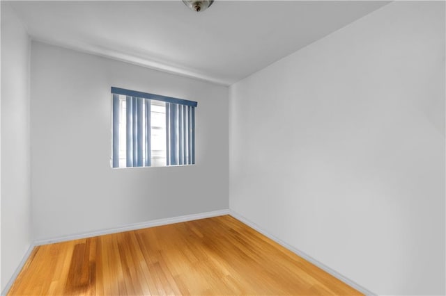 empty room featuring light wood-type flooring and baseboards