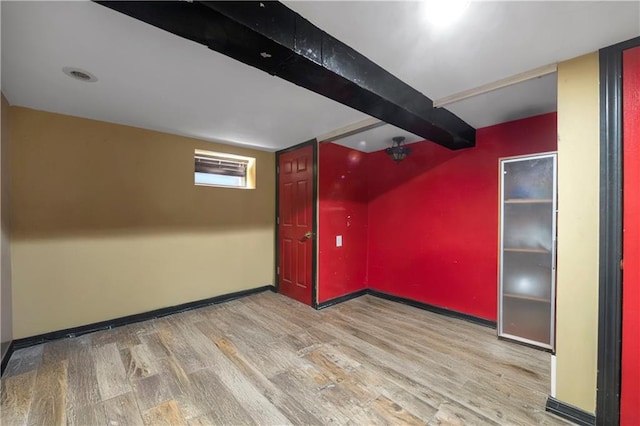 basement with baseboards and wood finished floors