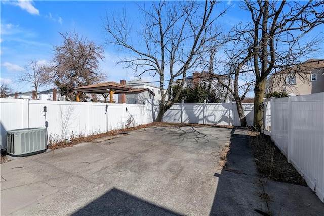 view of yard with a fenced backyard, a patio, and central AC