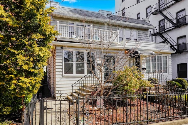 view of front of home featuring a fenced front yard and a balcony