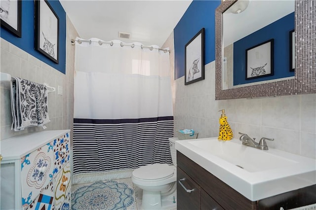 bathroom with a shower with curtain, toilet, tile walls, and vanity