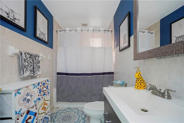 full bathroom with visible vents, toilet, a shower with shower curtain, tile walls, and vanity