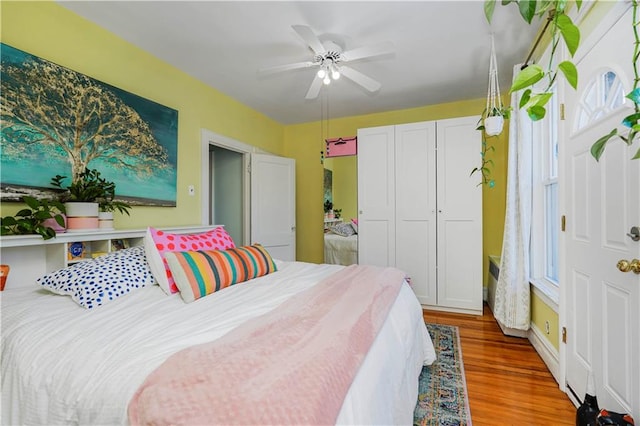 bedroom with a closet, wood finished floors, and a ceiling fan