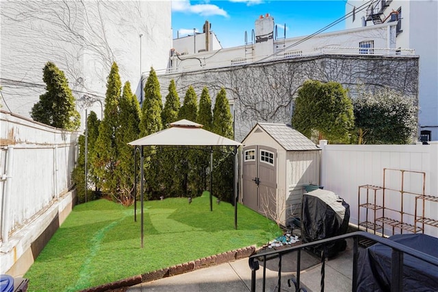 view of patio / terrace with an outdoor structure, a storage unit, a fenced backyard, and a grill