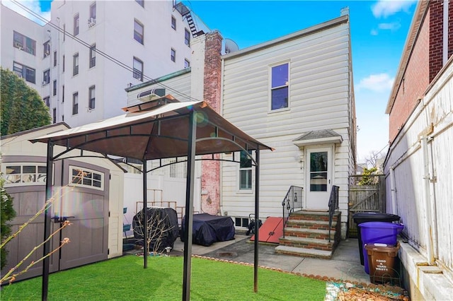 rear view of property featuring a gazebo, a yard, and fence