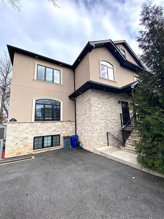 exterior space featuring a patio, stone siding, and stucco siding