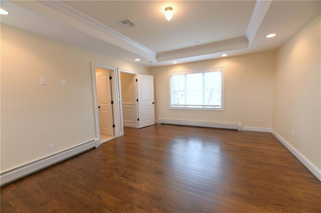 empty room with a raised ceiling, ornamental molding, wood finished floors, and a baseboard radiator