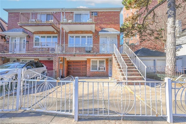 multi unit property featuring a fenced front yard and brick siding