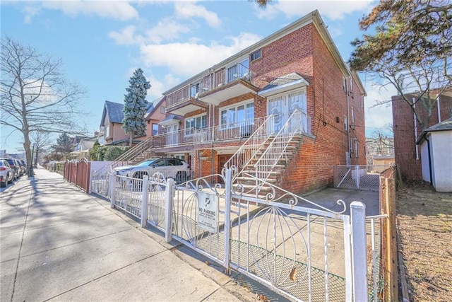 view of front of property with a gate, a residential view, brick siding, and a fenced front yard