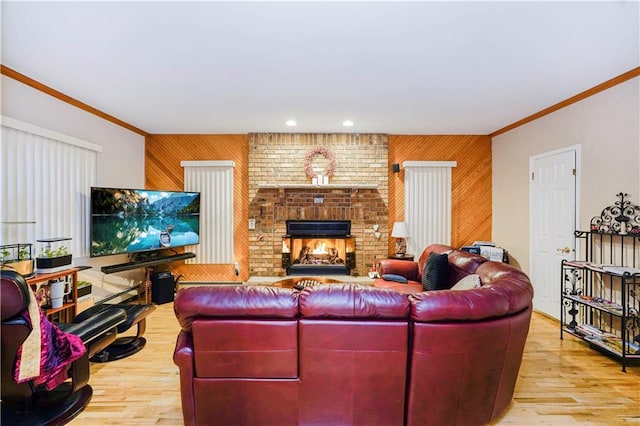 living room with a brick fireplace, wood finished floors, wood walls, and ornamental molding