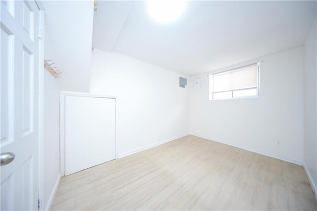 spare room featuring light wood-type flooring and baseboards