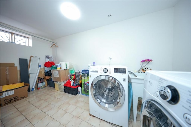 laundry area featuring washer and clothes dryer, light tile patterned floors, and laundry area