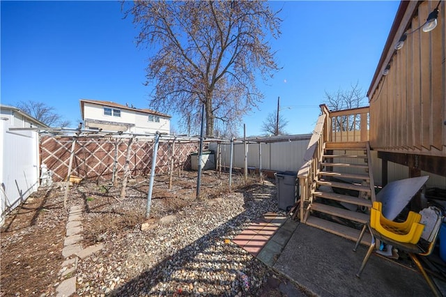 view of yard featuring a fenced backyard and stairs