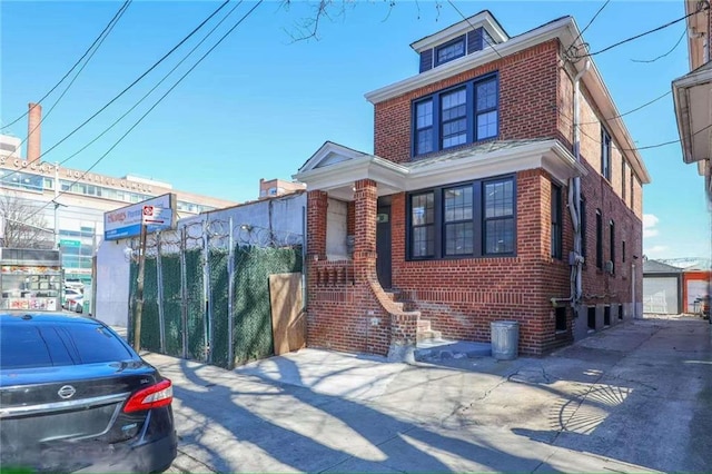 traditional style home with brick siding and fence