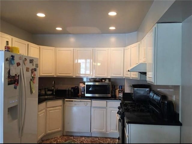 kitchen with white appliances, recessed lighting, white cabinets, under cabinet range hood, and dark countertops