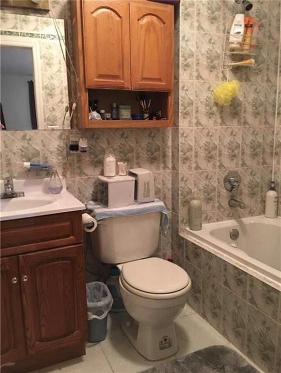 full bath featuring toilet, tile walls, vanity, and tile patterned flooring