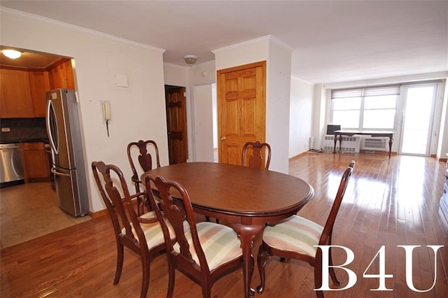 dining room featuring radiator, ornamental molding, and wood finished floors
