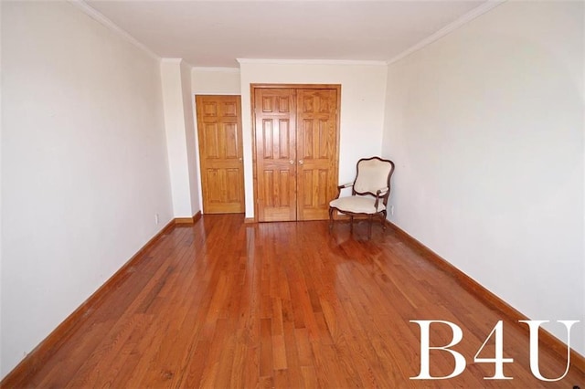 interior space featuring crown molding, baseboards, and wood finished floors