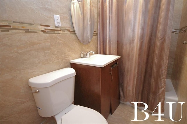 bathroom featuring vanity, shower / bath combo, toilet, and tile walls