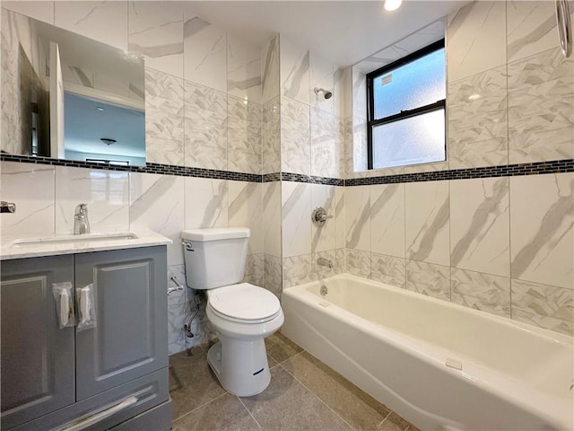 bathroom with toilet, vanity, tile walls, and  shower combination