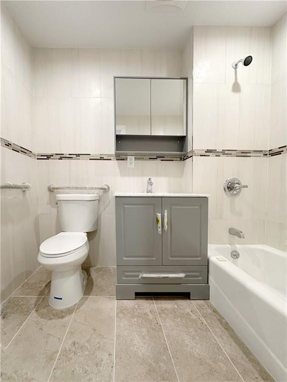 bathroom featuring tub / shower combination, toilet, tile walls, and vanity