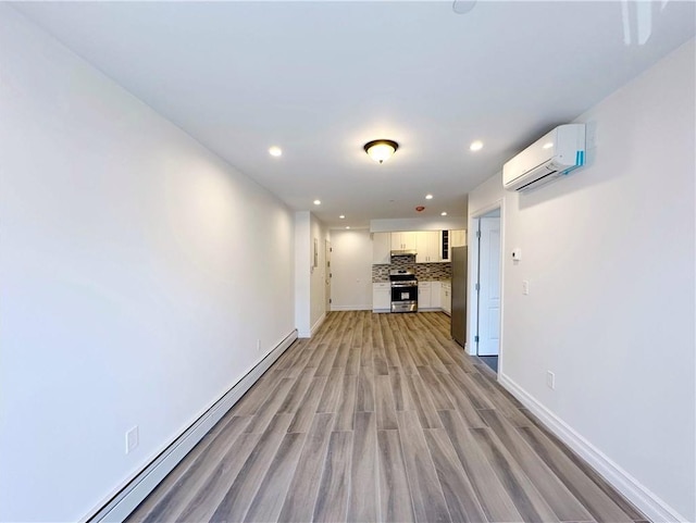 unfurnished living room with light wood-type flooring, a wall mounted AC, recessed lighting, baseboards, and baseboard heating