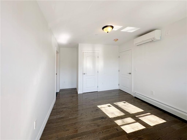 unfurnished room featuring a baseboard radiator, baseboards, dark wood finished floors, and a wall mounted AC