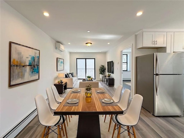 dining space with an AC wall unit, recessed lighting, light wood-type flooring, and a baseboard radiator