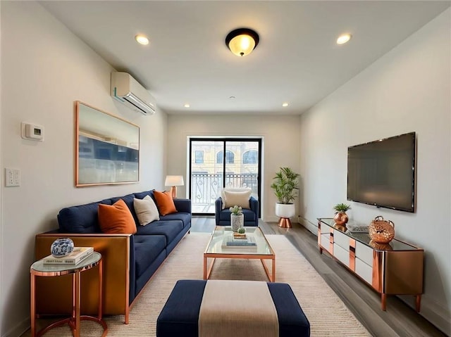 living area with an AC wall unit, recessed lighting, wood finished floors, and baseboards