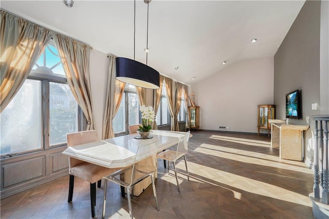 dining space with high vaulted ceiling and baseboards