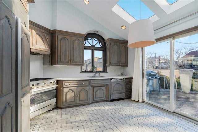 kitchen featuring light countertops, dishwashing machine, stainless steel range with electric cooktop, a skylight, and a sink