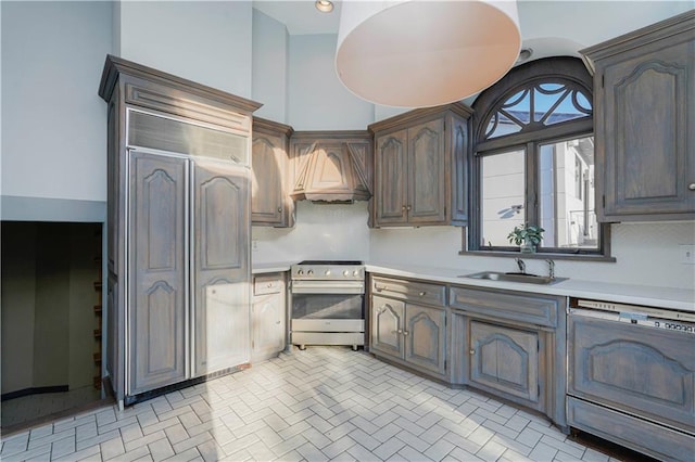 kitchen featuring custom range hood, a sink, light countertops, stainless steel electric range oven, and dishwasher