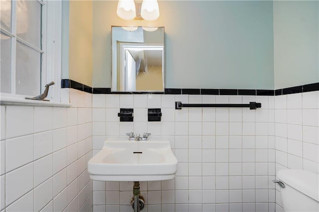 bathroom with tile walls and toilet