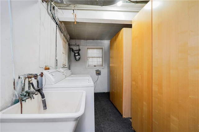 washroom with independent washer and dryer and a sink