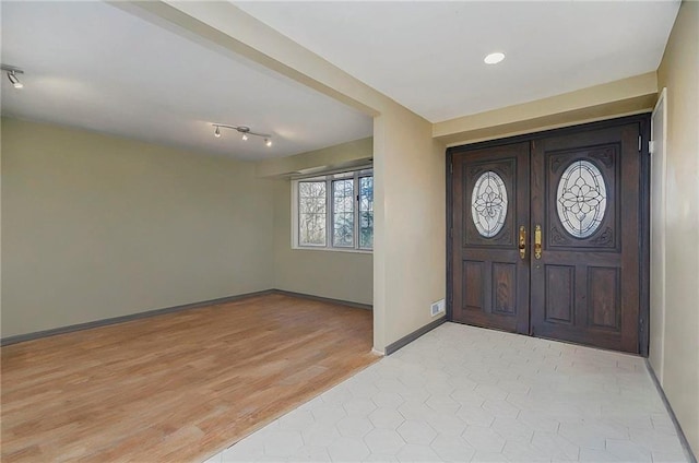 entrance foyer with light wood-style floors, baseboards, and french doors