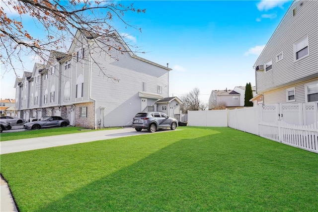 view of yard with a residential view, driveway, and fence