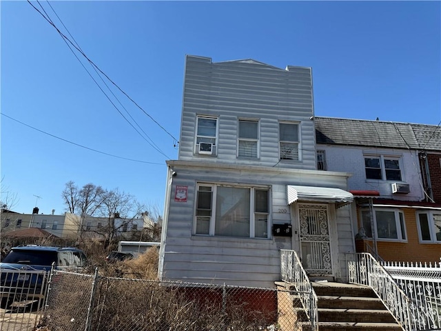 view of front of home with cooling unit and a fenced front yard