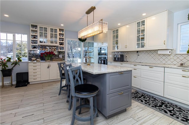 kitchen with white cabinetry, a center island, a healthy amount of sunlight, and a breakfast bar