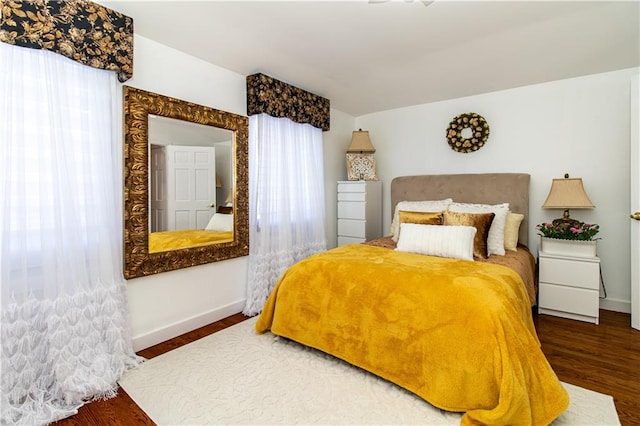 bedroom with baseboards and wood finished floors