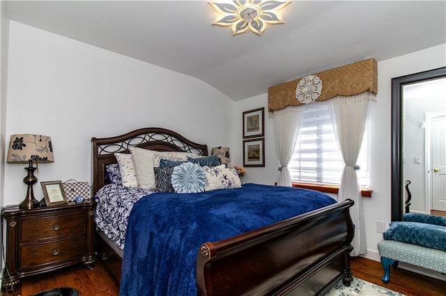 bedroom with wood finished floors and vaulted ceiling