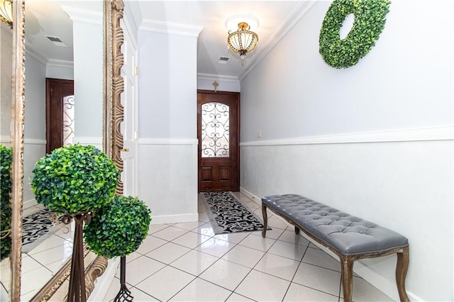 foyer entrance with light tile patterned floors, a notable chandelier, crown molding, and visible vents