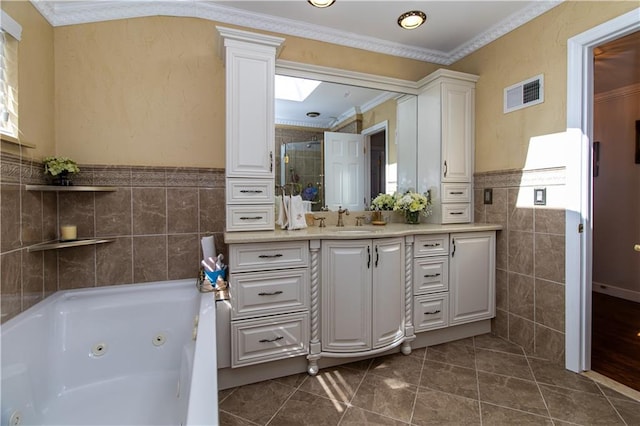 full bathroom with visible vents, crown molding, vanity, a stall shower, and tile walls