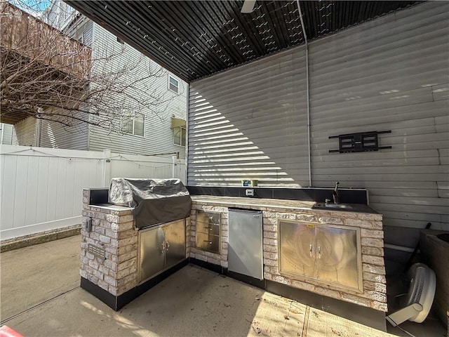 view of patio featuring area for grilling, fence, and a sink